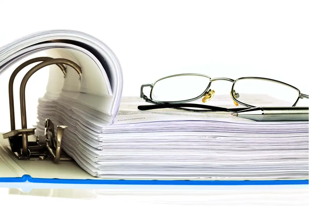 Billede af et par briller på en ringbind-mappe